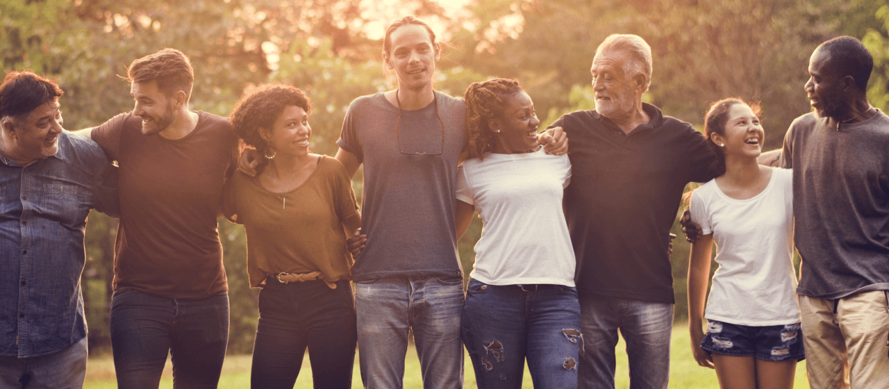 Several people of different backgrounds, genders and ages stand side by side and smile at each other. Together they can make a difference and do good with their Epic Moments.