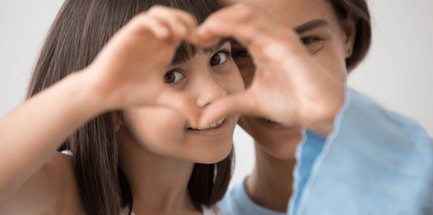 Mutter und Tochter formen ein Herz mit ihren Händen. Etwas Gutes zu tun, erfüllt uns mit Glück und Zufriedenheit.