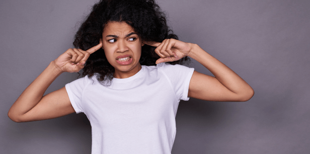 A woman covers her ears in disgust as she has symbolically had enough of penetrative advertising.